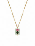 A gold chain necklace featuring a rectangular beaded pendant with a pixelated flower design in pink, green on a mint background.